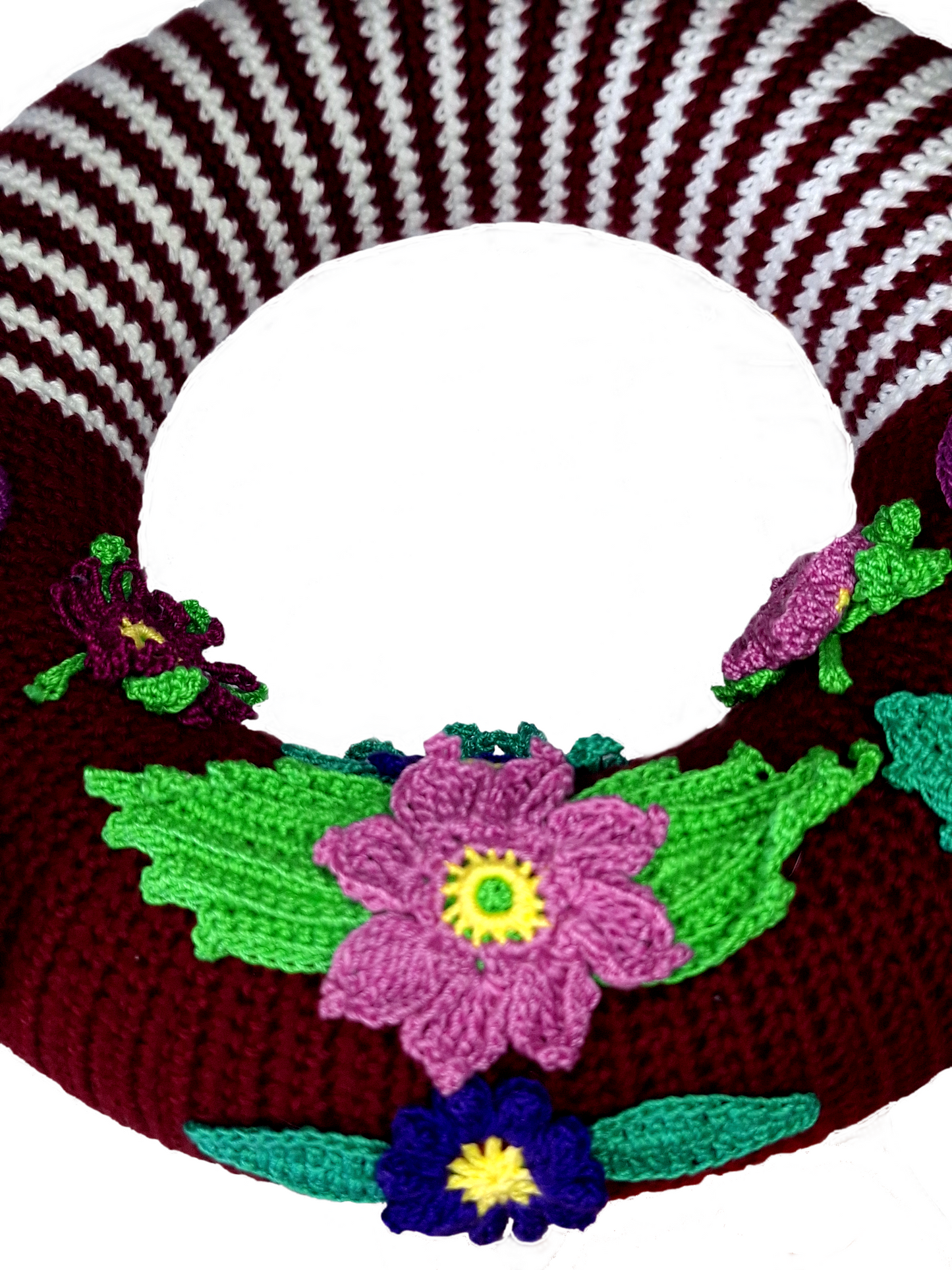 Pormenor das flores centrais, uma rosa velho mais ao centro da grinalda, e outra mais a baixo em azul, ambas com folhas em diferentes tons de verde.