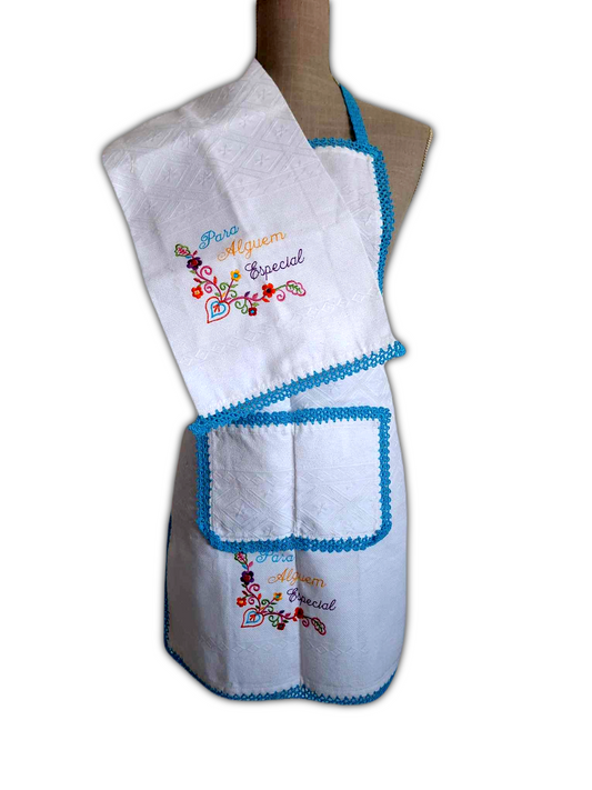 Bonito conjunto de avental e saco do pão, com tecido branco 100% algodão e picô azul. O avental tem um bolso na parte da frente e ambos os artigos têm um pequeno bordado decorativo.