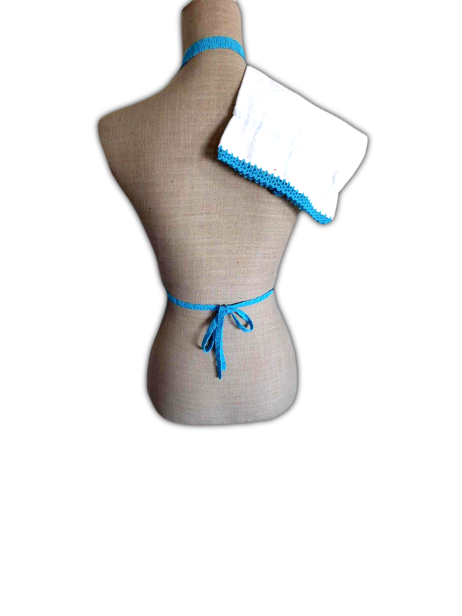 Parte de trás do avental, para destacar que a fita que passa a volta do pescoço e as que o atam, são feitas em crochet.