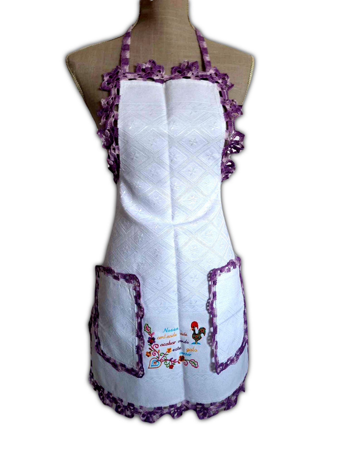 Aqui temos somente o avental, para dar destaque a todos os seus pormenores. Este é de tecido branco 100% algodão, com picô roxo matizado a toda a volta e ainda dois bolsos na parte da frente também com o mesmo picô e um bonito bordado decorativo, entre os bolsos.