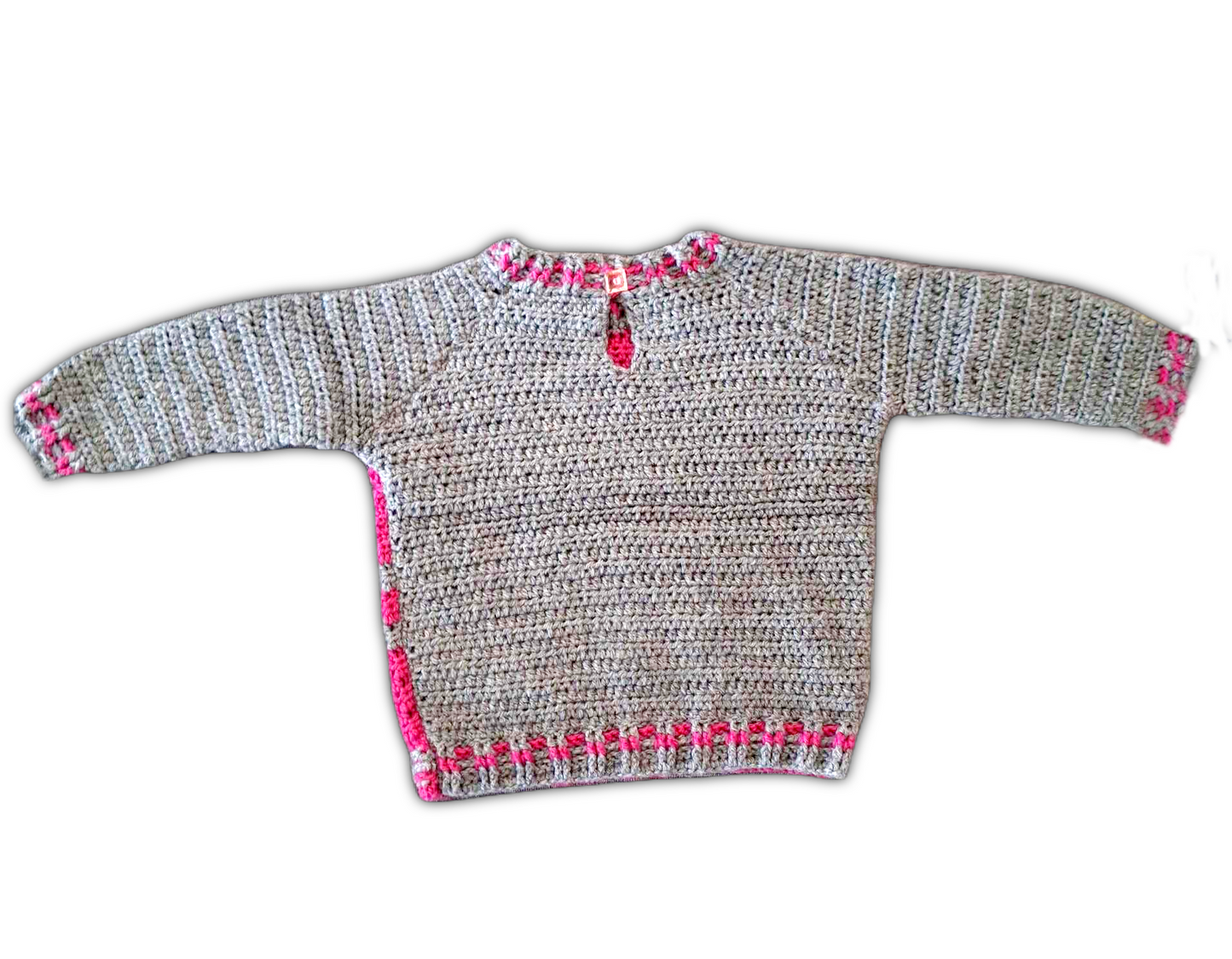 Parte de trás da camisola completamente em cinzento com pequenos pormenores em rosa nos punhos, a volta do pescoço e  junto a costura. Tem ainda um pequeno botão na zona do pescoço para ajudar a vestir e despir.