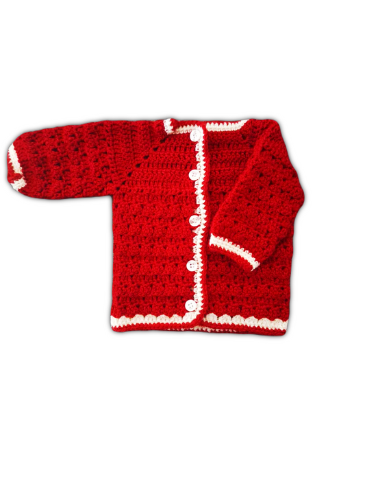 casaco é feito em crochê vermelho intenso, com uma textura uniforme de pontos bem definidos. As bordas, incluindo a gola, os punhos e a abertura frontal, são contornadas com um fio branco, criando um contraste bonito e delicado. A peça tem mangas compridas e um fecho frontal com três pequenos botões arredondados. O acabamento meticuloso revela o cuidado artesanal, tornando esta peça única e especial.