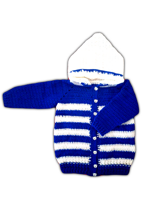 O casaco é predominantemente azul, com um padrão uniforme de crochê que confere textura e suavidade à peça. As bordas, incluindo punhos, extremidades e abertura frontal, são contornadas com fio branco, criando um contraste delicado. O capuz também é branco, acrescentando charme e funcionalidade. Na parte da frente, a peça conta com oito botões arredondados, estrategicamente posicionados para um fecho seguro e confortável. 