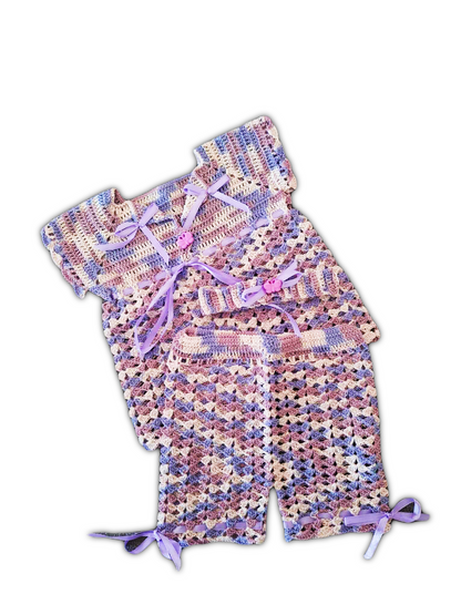 Conjunto de bebé com três peças em fio matizado em tons de lilás e branco. Inclui uma blusinha, calções com elástico e uma fita para a cabeça. O padrão matizado dá um efeito suave e ondulado às peças.