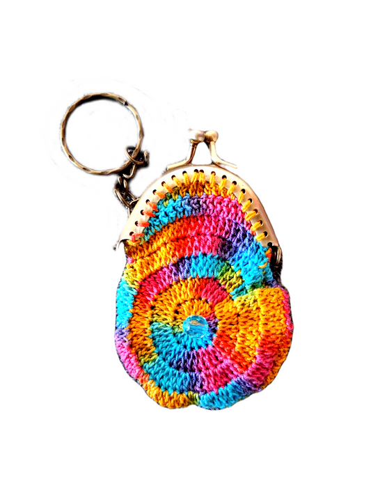 Este porta chaves é no formato de uma carteirinha com uma cor matizada bastante colorida. O que torna este artigo bem especial é que como tem um fecho metalico incorporado pode mesmo ser usado como um pequeno porta moedas.