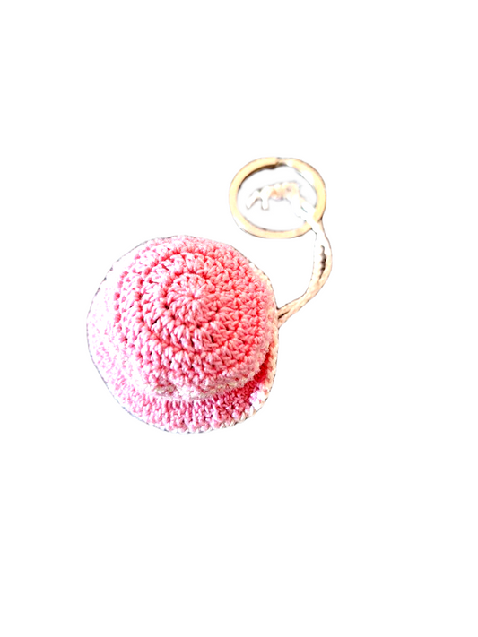 Porta chaves no formato de um bonito chapéu com a aba pequena, maioritariamente cor de rosa com alguns detalhes em bege. 
