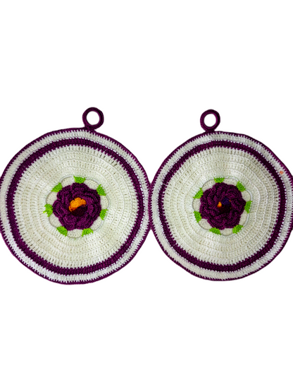 Parte frontal das pegas. Estas são redondas, em branco e roxo com uma bonita flor central em roxo com as suas folhas verdes e o centro em tons de amarelo. 