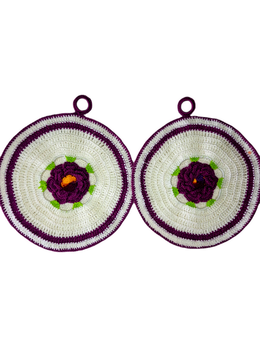 Parte frontal das pegas. Estas são redondas, em branco e roxo com uma bonita flor central em roxo com as suas folhas verdes e o centro em tons de amarelo. 